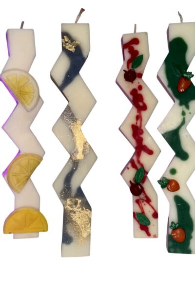 Handcrafted zig-zag soy wax Easter candles with decorative fruit and botanical designs